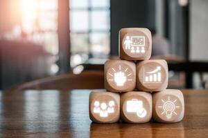 Wooden blocks with icons symbolizing learning, leadership, growth, and teamwork in a modern office setting. photo
