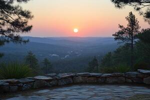 Sunset Over a Ridge of Trees with Stone Wall in Foreground photo