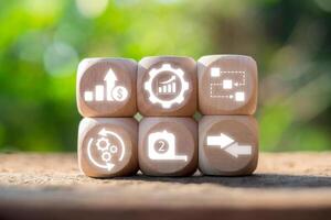 Wooden blocks with productivity symbols illustrating growth, efficiency, and workflow against a natural backdrop. photo