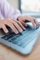 Hands typing on a laptop keyboard in a well-lit workspace, showcasing modern technology and productivity. photo