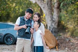 A family bonding over photography in a natural outdoor setting, capturing moments with a professional camera. photo