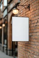 A blank billboard is mounted on an old red brick wall, creating a canvas for promotions. Soft lighting from street lamps enhances the nostalgic downtown atmosphere during golden hour photo