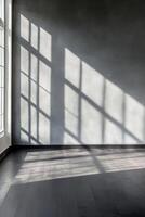 A modern space with deep charcoal walls and a matte black wooden floor, illuminated by natural light streaming through a single window. Shadows create a high-contrast, moody setting photo