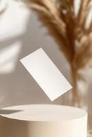 A blank business card hovers silently, casting a soft shadow below it. The blurred background features a smooth gradient, enhancing the modern, sleek aesthetic perfect for branding photo