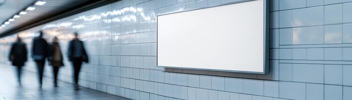 A sleek blank billboard is mounted on the tiled wall of a contemporary subway station. Commuters walk by, adding to the vibrant, dynamic atmosphere of daily transit life photo