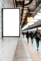 Blank advertising space is mounted on the tiled wall of a contemporary subway station. Commuters pass by, contributing to the vibrant urban atmosphere of the setting photo