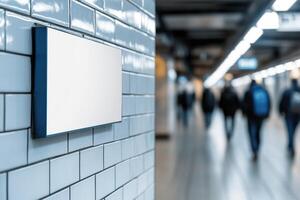 A sleek blank billboard is mounted on a tiled wall in a contemporary subway station. Softly blurred commuters pass by, enhancing the dynamic urban environment ideal for transit advertising photo