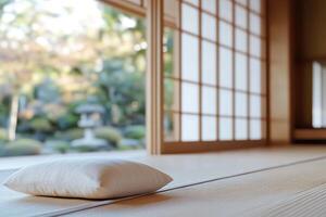 This space features tatami flooring and sliding shoji doors, creating a tranquil atmosphere. Large windows offer a view of a serene garden, enhancing relaxation and mindfulness photo