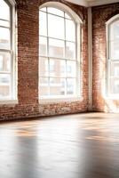 Bright and airy room featuring a rustic red brick accent wall and dark hardwood flooring. Large industrial windows allow natural light to illuminate the space, creating a stylish backdrop photo
