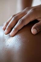A massage therapist is gently massaging a client's shoulders in a peaceful spa environment. Soft candlelight and essential oils enhance the calming atmosphere, creating a soothing experience photo