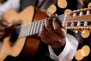A skilled guitarist is deeply focused on strumming their acoustic guitar on a softly lit stage. The ambiance features warm lighting that enhances the excitement of the audience photo