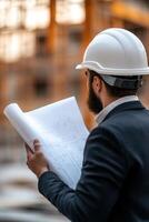 At a bustling construction site, a professional architect in a suit and hard hat reviews detailed blueprints while engaging in discussion with colleagues about the ongoing project photo