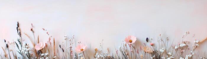 A rustic strip of wild meadow grass features delicate wildflowers against a softly blurred pastel backdrop. Ideal for floral designs and eco-conscious branding with a whimsical touch photo