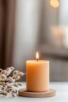 A cozy amber candle flickers gently in a softly lit room, casting a warm glow. The background features neutral hues, creating a calming ambiance perfect for relaxation and serenity at home photo
