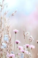 A charming strip of wild meadow grass adorned with tiny colorful wildflowers sits against a softly blurred pastel background, providing a whimsical touch perfect for branding or text photo