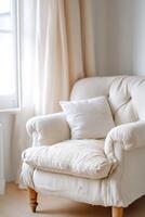 A soft fabric armchair shows significant dust buildup and discoloration in a inviting reading nook. The setting is bright and spacious, ideal for promoting upholstery cleaning services photo