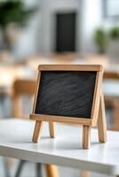 A rustic wooden-framed chalkboard sits on a desk in a classroom, featuring softly drawn alphabet letters. The top section is blank for additional text, making it ideal for educational activities photo