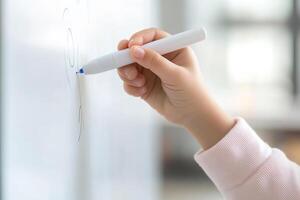 A young child is engaged in writing and drawing on a whiteboard using a dry-erase marker. The setting is an inviting classroom that encourages creativity and learning photo