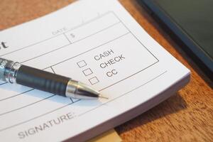 Payment options listed on a financial document with a pen photo