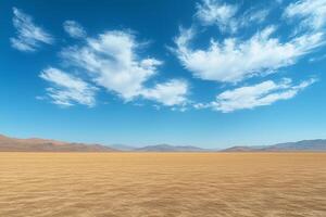 Wispy clouds floating over arid desert terrain, rocky mountain silhouettes defining distant horizon under expansive blue sky copy space photo