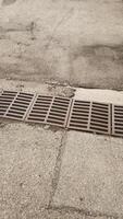 Rusty grate draining water on a sidewalk in cesky krumlov photo
