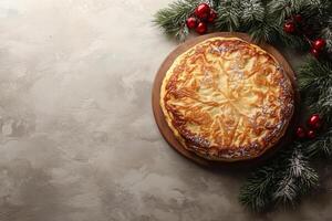 Delicious king cake with fir branches and red balls on gray background, celebrating epiphany, top view copy space photo