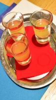 Limoncello glasses resting on silver tray with red napkin, capturing bright italian refreshment in bibione seaside setting photo