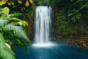 Scenic waterfall hidden paradise concept. Lush waterfall cascading into a serene blue pool surrounded by vibrant green foliage. photo