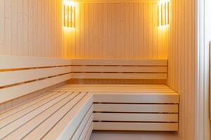 Relaxing spa self-care day concept. Spacious wooden sauna with warm lighting for relaxation and wellness. photo