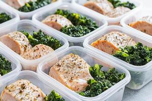 Healthy meal prep inspiration concept. Healthy meal prep containers with salmon and broccoli arranged neatly. photo