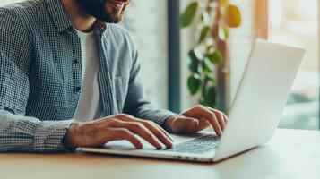 Digital transformation e-learning courses concept. A man typing on a laptop in a bright, modern workspace with plants nearby. photo