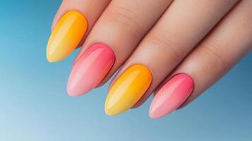 Spring nail art concept. Vibrant, colorful manicure featuring yellow and pink ombre nails on a hand against a blue background. photo