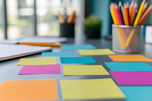 Startup brainstorming session concept. Colorful sticky notes scattered on a desk with stationery in the background. photo