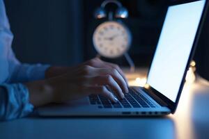 Inspirational success story motivation concept. Nighttime work scene with a person typing on a laptop beside a clock. photo