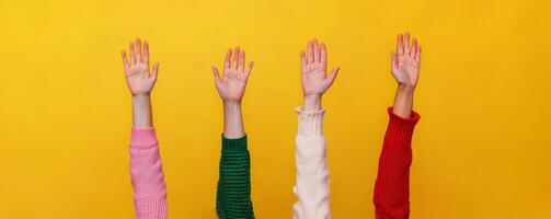 Inspirational success story motivation concept. Colorful hands raised against a bright yellow background. photo