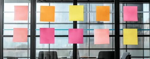 Startup brainstorming session concept. Colorful sticky notes arranged on a glass wall in a modern office setting. photo