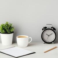 Management efficiency and goal-setting concept. A cozy workspace with a plant, coffee, clock, and blank notebook on a clean surface. photo