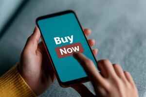e-commerce checkout process concept A person tapping a smartphone with a Buy Now button displayed on the screen. photo