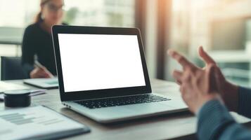 Teamwork and leadership with goal-setting concept. Laptop on a table with a person gesturing during a business meeting in a well-lit office environment. photo