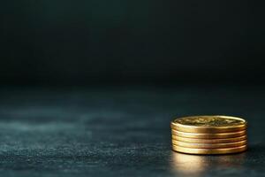 investment business clean background. Stacked gold coins on a dark surface, symbolizing wealth and investment. photo