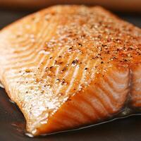 Salmon fillet with crispy skin concept. Freshly cooked salmon fillet on a dark plate. photo