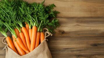Carrots in eco-friendly market bag concept. Fresh carrots in a burlap sack on a wooden surface. photo