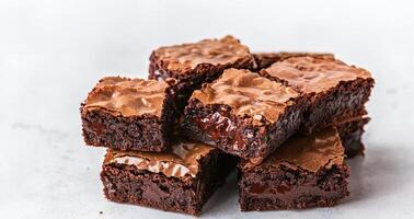 Rich brownie with chocolate chunks concept. A tempting stack of rich, fudgy brownies showcasing a glossy top and gooey interior, perfect for dessert lovers. photo