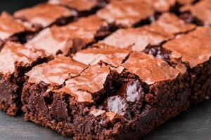 Rich brownie with chocolate chunks concept. A close-up of rich, fudgy brownies cut into squares, showcasing a glossy top and gooey chocolate chunks. photo