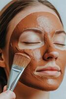 Self-care routines for Wellness concept. A woman applies a chocolate face mask, promoting skincare and relaxation while enhancing her beauty routine. photo