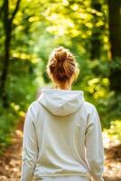 Self-care routines for Wellness concept. A person walks through a sunlit forest path, surrounded by lush greenery, creating a serene and peaceful atmosphere. photo