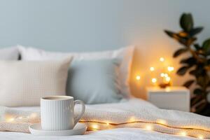 Self-care routines for Wellness concept. Cozy bedroom scene featuring a cup of coffee, soft pillows, and warm fairy lights, creating a serene and inviting atmosphere. photo