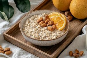 Self-care routines for Wellness concept. A bowl of oatmeal topped with almonds and an orange slice, served on a wooden tray, accompanied by fresh oranges, creating a healthy breakfast scene. photo