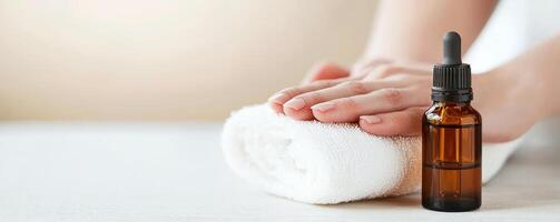 Self-care routines for Wellness concept. A person's hands on a rolled towel beside a bottle of essential oil, evoking relaxation and wellness. photo