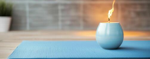 Self-care routines for Wellness concept. Blue candle holder with a flickering flame, set on a textured blue mat, against a softly lit background featuring greenery. photo
